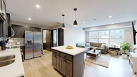 Located at 1625 Marshall Ave in Saint Paul, MN, this well-designed 2-bedroom, 2-bathroom unit offers a thoughtful single-floor layout that maximizes every square foot. The open-concept living and kitchen area forms the heart of the space, where light hardwood-style flooring flows seamlessly throughout. The kitchen is outfitted with dark, shaker-style cabinetry, a white subway tile backsplash, stainless steel appliances including a full-size refrigerator, range, microwave, and dishwasher, and a central island with a clean white countertop and stylish pendant lighting above. The adjoining living room is bright and airy, anchored by large windows that invite natural light and offer views of the surrounding neighborhood. Both bedrooms are comfortably sized, with the primary bedroom featuring a window with outdoor views and a spacious closet with dark panel doors. Each of the two bathrooms is finished with dark wood vanity cabinetry, white countertops, a large mirror, and a shower-tub combination. The overall aesthetic is modern and cohesive, with neutral tones, recessed lighting, and clean finishes that create a polished, move-in-ready atmosphere throughout.