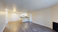 This single-floor residence offers a thoughtfully designed layout that balances open communal spaces with comfortable private areas. The living room serves as the heart of the home, featuring rich wood-look flooring, a fireplace, and a sliding glass door fitted with vertical blinds that invite natural light and provide access to the outdoors. A ceiling-mounted fan and a wall-mounted HVAC unit ensure year-round comfort throughout the living area.

The kitchen is seamlessly integrated into the open-plan layout and is equipped with white shaker-style cabinetry, dark countertops, a stainless steel sink, and a dishwasher. A peninsula with additional counter space and a skylight overhead adds both functionality and brightness to the cooking area.

The two bedrooms are finished with plush carpeting and neutral-toned walls, offering a calm and restful atmosphere. Each room provides ample space and connects conveniently to the rest of the home.

Both bathrooms are cleanly appointed with tile flooring, white vanities, and full tub-shower combinations. One bathroom features a lighted mirror and built-in storage cabinetry, adding a refined touch. Throughout the residence, clean lines, neutral tones, and consistent finishes create a cohesive and move-in-ready environment.