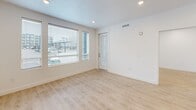 This thoughtfully designed 2-bedroom, 3-bathroom unit in Salt Lake City offers a clean, modern aesthetic across a well-utilized single floor. The open-concept layout seamlessly connects the living room, dining area, and kitchen, creating a bright and airy communal space bathed in natural light from large windows. Light-toned luxury vinyl plank flooring flows consistently throughout, complementing the crisp white walls and recessed lighting.

The kitchen is a standout feature, showcasing rich walnut-toned cabinetry, white quartz countertops, a classic subway tile backsplash, and a full suite of stainless steel appliances including a refrigerator with ice maker, range, microwave, and dishwasher. A central island provides additional prep space and casual seating.

Both bedrooms are generously sized, filled with natural light through well-placed windows, and include dedicated closet space — with six closets total throughout the unit. The primary bedroom offers a comfortable, private retreat. Each of the three bathrooms features walnut-toned vanity cabinetry, white quartz counters, brushed nickel fixtures, and a tub-shower combination. Additional conveniences include an in-unit laundry area, a balcony, and a connected hallway for efficient circulation.