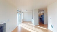 Located in Portland's vibrant SW neighborhood, this single-floor apartment offers a well-designed layout filled with natural light throughout. The open living area features warm hardwood-style flooring, crisp white walls, and a standout fireplace with a tile surround as the room's focal point. Large floor-to-ceiling windows and a sliding glass door lead to a private balcony with city views, flooding the space with daylight.

The kitchen is thoughtfully arranged in a U-shaped configuration, offering ample light wood cabinetry, dark countertops, and a full suite of stainless steel appliances including a range, built-in microwave, dishwasher, and refrigerator. Hardwood-style flooring continues seamlessly from the living area into the kitchen.

The bedrooms are bright and well-proportioned, each featuring large windows with exterior views and the same consistent hardwood-style flooring. The unit includes two bathrooms: one with a standalone corner glass-enclosed shower, tile flooring, and a vanity, and a second featuring a sink with a wide mirror and light wood cabinetry. The overall aesthetic is clean, modern, and functional, well-suited to urban living in Portland.