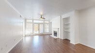 This well-appointed 2-bedroom, 2-bathroom single-floor residence in Fort Worth, TX, offers a thoughtfully designed layout with a welcoming entrance and a hallway connecting the key living spaces. The open living room serves as the heart of the home, showcasing rich hardwood-style flooring, crown molding, a ceiling fan, and a classic white-mantled fireplace flanked by built-in shelving — ideal for display or storage. Large French doors with transom windows flood the space with natural light and provide outdoor access. The kitchen is equipped with stainless steel appliances, including a range, microwave, dishwasher, and refrigerator, complemented by granite countertops, a dark subway tile backsplash, and crisp white shaker cabinetry. Both bedrooms feature plush wall-to-wall carpeting, ceiling fans, and windows that bring in ample natural light, with the primary bedroom offering direct outdoor access via a private door. Three closets provide generous storage throughout. The bathrooms are finished with granite-topped white vanities and hardwood-style flooring. The exterior features a stone perimeter wall with iron fencing, adding character to the outdoor surroundings.