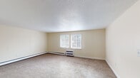 Located at 8 Derry Park Dr in Middleboro, Massachusetts, this single-floor unit offers a functional and comfortable layout across several well-defined living spaces. The interior is finished with warm, neutral-toned walls throughout, creating a cohesive and inviting atmosphere.

The living area is generously sized, featuring wall-to-wall carpeting, a wall-mounted air conditioning unit, and baseboard heating. A sliding glass door floods the space with natural light and provides views of the surrounding landscape. An entry area includes a coat closet and connects seamlessly to the living space, with the kitchen visible nearby.

The kitchen is efficiently arranged in an L-shaped configuration, outfitted with honey-toned wood cabinetry, dark granite-style countertops, and light hardwood-style flooring. White appliances include a gas range, dishwasher, refrigerator, and built-in microwave, providing full functionality.

The bedroom is a well-proportioned, carpeted space featuring a large window that brings in ample natural light and offers outdoor views, along with baseboard heating and access to a closet area.

The bathroom is clean and simply designed, with light wood-style flooring, a vanity with dark cabinet hardware, a full bathtub with shower, and baseboard heating.