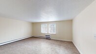 Located at 8 Derry Park Dr in Middleboro, Massachusetts, this single-floor unit offers a functional and comfortable layout across several well-defined living spaces. The interior is finished with warm, neutral-toned walls throughout, creating a cohesive and inviting atmosphere.

The living area is generously sized, featuring wall-to-wall carpeting, a wall-mounted air conditioning unit, and baseboard heating. A sliding glass door floods the space with natural light and provides views of the surrounding landscape. An entry area includes a coat closet and connects seamlessly to the living space, with the kitchen visible nearby.

The kitchen is efficiently arranged in an L-shaped configuration, outfitted with honey-toned wood cabinetry, dark granite-style countertops, and light hardwood-style flooring. White appliances include a gas range, dishwasher, refrigerator, and built-in microwave, providing full functionality.

The bedroom is a well-proportioned, carpeted space featuring a large window that brings in ample natural light and offers outdoor views, along with baseboard heating and access to a closet area.

The bathroom is clean and simply designed, with light wood-style flooring, a vanity with dark cabinet hardware, a full bathtub with shower, and baseboard heating.