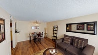 Located at 4665 Paris St in Denver, Colorado, this single-floor unit offers a practical and comfortable layout designed to maximize functionality throughout. The open living area serves as the heart of the home, featuring warm wood-style flooring, neutral-toned walls, and a textured ceiling. A large window dressed with sheer curtains allows natural light to fill the space, creating a bright and welcoming atmosphere. The living area flows seamlessly into a dedicated dining space, which is highlighted by a ceiling fan with light fixture overhead—an practical touch for everyday comfort.

The kitchen is outfitted with dark espresso cabinetry, dark granite-style countertops, a stainless steel sink, and a white electric range with overhead ventilation, providing ample storage and counter space for meal preparation.

The bedroom is carpeted for comfort and features a generously sized closet with louvered bi-fold doors, offering substantial storage. A window admits natural light, enhancing the room's airy feel.

The full bathroom includes a white vanity with dark granite-style countertops, a single sink, and a tiled shower-tub combination, maintaining a clean and cohesive aesthetic consistent with the rest of the unit.