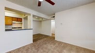 Located at 4101 W Union Hills Dr in Phoenix, AZ, this one-bedroom, one-bathroom unit delivers a practical and well-organized single-floor layout. The open living area features neutral-toned wall-to-wall carpeting, a ceiling fan overhead, and a textured ceiling, creating a comfortable and airy atmosphere. A half-wall pass-through connects the living space to the kitchen, enhancing the sense of openness between the two areas. The galley-style kitchen is outfitted with warm wood cabinetry on both sides, dark countertops, a double sink, a white refrigerator, and a white electric range, all set atop wood-look vinyl flooring beneath recessed overhead lighting. The bedroom is a well-proportioned space featuring plush carpeting, a window dressed with vertical blinds that allows natural light to filter in, and access to a dedicated closet. The bathroom is clean and functional, featuring a full-size soaking tub with an overhead shower, wood-look flooring, and a crisp all-white finish throughout. The unit's neutral color palette and efficient use of space make it a straightforward and practical living option in the Phoenix area.