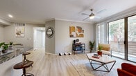 This single-story residence offers a thoughtfully designed layout with light-toned walls, crown molding, and light wood-style flooring throughout the main living areas. The living room serves as the centerpiece of the home, featuring a ceiling fan, crown molding, and a sliding glass door that opens to a private balcony, filling the space with natural light. A dedicated dining area adjacent to the living room provides an intimate setting, complete with its own decorative touches and convenient access to the rest of the unit.

The galley-style kitchen is well-equipped with gray cabinetry, granite countertops, a subway tile backsplash, stainless steel appliances, and a breakfast bar that connects to the living area. Two bedrooms are finished with plush carpeting, ceiling fans, and ample natural light from multiple windows. One bedroom includes access to a generously sized walk-in closet outfitted with wire shelving on multiple walls, offering substantial storage capacity. The bathroom features a full soaking tub and shower combination with large-format tile surround and wood-style flooring. Throughout, the neutral color palette and consistent finishes create a cohesive and comfortable living environment.