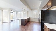 This well-appointed Denver residence offers four bedrooms and two bathrooms across a generous single-floor layout. The open-concept living and kitchen area serves as the heart of the home, anchored by a large island with a white countertop, dark espresso cabinetry, pendant lighting, and black stainless appliances. Hardwood-style flooring runs throughout the main living spaces, adding warmth and continuity. Floor-to-ceiling windows and sliding glass doors flood the living area with natural light and provide direct access to a private balcony with outdoor views — a standout feature of the space.

The four bedrooms are carpeted for comfort, each offering a calm, neutral palette and ample natural light from well-placed windows with blinds. Every bedroom benefits from dedicated closet space, with wire-rack shelving for organized storage. Two full bathrooms serve the residence; each features wood-toned vanities with white countertops, wood-look flooring, and a full tub-shower combination. Clean white walls and recessed lighting throughout give the home a bright, modern aesthetic. Hallways connect the private areas of the home seamlessly, contributing to a functional and comfortable flow across the entire floor plan.