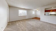 Located in Riverside, Missouri, this 2-bedroom, 1-bathroom single-floor unit offers a practical and well-organized layout across a comfortable footprint. The expansive living room features plush wall-to-wall carpeting, a ceiling fan, and multiple windows that invite natural light and outdoor views, creating a bright and open atmosphere. The adjoining dining room provides a dedicated space for meals, while a separate den offers additional flexibility for a home office or secondary lounge area. The kitchen is equipped with warm wood-toned cabinetry, laminate countertops, hardwood-style flooring, and includes a refrigerator, stove, and dishwasher. A hallway connects the main living spaces to the private quarters. The generously sized primary bedroom features carpet flooring and a window with natural light, while the second bedroom is similarly appointed with carpet and a window. Three closets throughout the unit provide ample storage. The full bathroom includes a tub-shower combination and a vanity. A dedicated utility room rounds out the functional layout. Textured ceilings are consistent throughout, contributing to the unit's classic residential character.