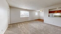 Located in Riverside, Missouri, this 2-bedroom, 1-bathroom single-floor unit offers a practical and well-organized layout across a comfortable footprint. The expansive living room features plush wall-to-wall carpeting, a ceiling fan, and multiple windows that invite natural light and outdoor views, creating a bright and open atmosphere. The adjoining dining room provides a dedicated space for meals, while a separate den offers additional flexibility for a home office or secondary lounge area. The kitchen is equipped with warm wood-toned cabinetry, laminate countertops, hardwood-style flooring, and includes a refrigerator, stove, and dishwasher. A hallway connects the main living spaces to the private quarters. The generously sized primary bedroom features carpet flooring and a window with natural light, while the second bedroom is similarly appointed with carpet and a window. Three closets throughout the unit provide ample storage. The full bathroom includes a tub-shower combination and a vanity. A dedicated utility room rounds out the functional layout. Textured ceilings are consistent throughout, contributing to the unit's classic residential character.