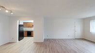 This single-floor unit at 201 Deer Valley Rd in Madison, WI offers a clean, functional layout with a cohesive design throughout. Light wood-style laminate flooring runs continuously across the living areas, bedrooms, kitchen, and bathroom, creating a unified and bright aesthetic against crisp white walls and white trim.

The open living area is generously proportioned, providing flexible space for a variety of furniture arrangements. A track lighting fixture overhead ensures consistent illumination. An adjacent room, also finished with the same flooring and neutral walls, features a built-in closet with a hanging rod, offering practical storage.

The kitchen is separated from the main living space by a partial wall, creating a defined yet connected cooking area. Warm medium-toned wood cabinetry with brushed nickel hardware lines both the upper and lower sections, complemented by granite-style countertops and a double-basin stainless steel sink. Black appliances, including a refrigerator and range, complete the kitchen.

The bathroom includes a tiled tub-and-shower combination with large-format neutral tiles, a wood-toned vanity, and wood-style flooring, maintaining the consistent material palette found throughout the unit.