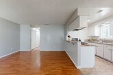 Located in Moreno Valley, CA, this single-story 2-bedroom, 1-bathroom unit offers a practical and comfortable layout across a well-utilized floor plan. The open-concept living and dining area is anchored by warm hardwood-style flooring and a textured ceiling, with a ceiling fan providing comfort and a large window with vertical blinds allowing natural light to fill the space. A peninsula with a granite-style countertop connects the living and dining area to the kitchen, functioning as a convenient breakfast bar. The galley-style kitchen is efficiently designed with white cabinetry lining both sides, granite-look countertops, a gas range, and a double sink — all finished with neutral tile flooring. The spacious primary bedroom features hardwood-style flooring, a ceiling fan, and a window with outdoor views, while the secondary bedroom offers tile flooring and its own ceiling fan. Both bedrooms are served by generous closet space, with five closets distributed throughout the unit. The full bathroom includes a tub-shower combination, a wood-toned vanity, and tile flooring. Additional conveniences include a dedicated laundry area and a hallway connecting all rooms for smooth circulation throughout the home.