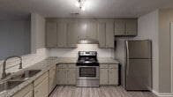 Located at 836 Ray Suggs Pl NW in Concord, NC, this single-floor residence offers a practical and cohesive layout designed for comfortable everyday living. The kitchen serves as a functional centerpiece, outfitted with stainless steel appliances including a range and refrigerator, granite-style countertops, gray cabinetry, classic white subway tile backsplash, and durable wood-look flooring. Track lighting illuminates the workspace, enhancing both functionality and style.

The bedrooms are carpeted throughout and finished with neutral gray walls, providing a calm and versatile atmosphere. Several rooms feature ceiling fans with integrated lighting, while natural light filters in through blinded windows in each room. The varied ceiling fixtures across the bedrooms offer subtle distinctions between spaces.

Two full bathrooms serve the residence. The primary bathroom includes a tub/shower combination, a vanity with granite-style countertops, gray cabinetry, a framed mirror, and brushed nickel fixtures, all set over wood-look flooring. The second bathroom features a clean white tub/shower enclosure with a curved curtain rod and brushed nickel hardware.

The overall aesthetic is consistent and modern, with neutral tones, updated finishes, and a well-organized floor plan visible in the dollhouse view, making this a well-appointed single-level home.