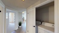 Located in Pasadena, CA, this single-story residence offers a thoughtfully designed layout with modern finishes throughout. The kitchen is a standout feature, showcasing warm wood cabinetry, light quartz countertops, a glass tile backsplash, and a full suite of stainless steel appliances including a gas range, microwave, and dishwasher. Large windows fitted with horizontal blinds flood the kitchen with natural light and offer views of the surrounding neighborhood. The open floor plan connects the kitchen to a spacious living area, where light-toned hardwood-style flooring, neutral walls, and generous windows create a bright and airy atmosphere. A ceiling fan adds comfort to the living space. The bedrooms are carpeted and well-proportioned, each equipped with ceiling fans and ample natural light from multiple windows. Closet space is provided via sliding-door closets with built-in rods and shelving. The bathroom features a clean, white tiled soaking tub and shower combination with matte black fixtures, lending a contemporary contrast. A dedicated in-unit laundry closet with louvered doors houses a full-size washer and dryer. Throughout the home, a consistent palette of white trim, neutral tones, and modern hardware ties each space together cohesively.