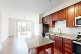 Located at 9142 Richmond Hwy in Fort Belvoir, Virginia, this one-bedroom, one-bathroom residence offers a thoughtfully designed single-level layout. The open-concept kitchen and living area serves as the heart of the home, where rich cherry wood cabinetry, granite countertops, and a full suite of stainless steel appliances — including a refrigerator, range, microwave, and dishwasher — create a polished and functional culinary space. A freestanding kitchen island with a granite top provides additional prep and dining space. Warm hardwood flooring flows throughout the main living areas, complemented by abundant natural light and track lighting overhead. Sliding glass doors open to a private balcony overlooking lush greenery, seamlessly blending indoor and outdoor living. The generously sized bedroom features plush carpeting, a ceiling fan, and a large window framing serene outdoor views. The bathroom is finished with matching granite countertops, rich cabinetry, and a tiled shower-tub combination. Additional conveniences include three closets, in-unit laundry, a utility room, and a hallway connecting the thoughtfully arranged spaces. The overall ambiance is clean, modern, and move-in ready.