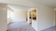 Located at 204 Caraway Rd in Reisterstown, Maryland, this single-floor residence offers a practical and comfortable layout throughout. The living area is finished with plush wall-to-wall carpeting and clean white walls, creating a bright, neutral backdrop. A pass-through opening connects the living space to the kitchen, which is equipped with white shaker-style cabinetry, stone-look countertops, a stainless steel sink, and a stainless steel refrigerator, complemented by hardwood-style flooring that adds warmth to the space.

The bedrooms feature the same soft carpeting found throughout the main living areas. One bedroom includes a panel ceiling and a window with views of mature, leafy trees, providing a quiet, nature-facing retreat. An additional bedroom offers built-in closet storage with sliding doors, adding functional organization to the space.

Two full bathrooms are present, each finished with white tile surround tub-shower combinations, wood-tone flooring, white vanities with solid countertops, and well-lit mirrors. The consistent white-toned finishes throughout the bathrooms lend a clean, cohesive appearance. Overall, this residence presents a straightforward, functional design with comfortable finishes suited for everyday living.