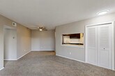 Located at 461 Greentree Ln in Milan, Michigan, this single-floor, 2-bedroom, 1-bathroom residence offers a practical and comfortable layout. The open living room is finished with plush wall-to-wall carpeting and features a ceiling fan overhead. A pass-through window connects the living area to the kitchen, which is equipped with dark cabinetry, white countertops, stainless steel appliances including an electric range, and durable wood-look vinyl flooring. Sliding glass doors in the living area lead to a private outdoor balcony, bringing in natural light and views of the surrounding landscape. The primary bedroom is a generously sized room with carpet flooring and an expansive wall of louvered bifold closet doors providing ample storage. The second bedroom also features carpet and a window with an outdoor view. Both bedrooms are finished in neutral warm-toned walls consistent with the rest of the home. The bathroom is clean and functional, featuring a full-sized soaking tub and shower combination with built-in shelving. Two hallways connect the rooms efficiently, and the overall design maintains a cohesive, neutral palette that provides a versatile backdrop for any furnishing style.
