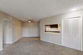 Located at 461 Greentree Ln in Milan, Michigan, this single-floor, 2-bedroom, 1-bathroom residence offers a practical and comfortable layout. The open living room is finished with plush wall-to-wall carpeting and features a ceiling fan overhead. A pass-through window connects the living area to the kitchen, which is equipped with dark cabinetry, white countertops, stainless steel appliances including an electric range, and durable wood-look vinyl flooring. Sliding glass doors in the living area lead to a private outdoor balcony, bringing in natural light and views of the surrounding landscape. The primary bedroom is a generously sized room with carpet flooring and an expansive wall of louvered bifold closet doors providing ample storage. The second bedroom also features carpet and a window with an outdoor view. Both bedrooms are finished in neutral warm-toned walls consistent with the rest of the home. The bathroom is clean and functional, featuring a full-sized soaking tub and shower combination with built-in shelving. Two hallways connect the rooms efficiently, and the overall design maintains a cohesive, neutral palette that provides a versatile backdrop for any furnishing style.