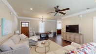 Located at 650 Dekalb St in Auburn, Alabama, this two-story home offers five bedrooms and five bathrooms across a generously sized layout spread over two floors. The main floor serves as the heart of the home, featuring an open living and dining area adorned with crown molding, rich hardwood flooring, recessed lighting, and a ceiling fan. A chandelier anchors the dining area, while large windows fitted with blinds allow ample natural light to fill the space. The kitchen is well-appointed with warm wood cabinetry featuring beadboard detailing, dark granite countertops, stainless steel appliances, and a U-shaped layout that maximizes workspace and storage. Each of the five bedrooms is comfortably sized, with the upper-floor bedrooms featuring carpet flooring and ceiling fans. Several bedrooms include en-suite access to a private bathroom, each outfitted with a shower-tub combination, wood vanity cabinetry, and white countertops. Every bedroom benefits from its own dedicated closet with built-in shelving and hanging rods. The second floor, accessed via a central staircase, provides additional bedroom accommodations. Throughout the home, a neutral color palette and consistent trim details create a cohesive, welcoming ambiance well-suited for comfortable everyday living.