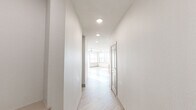Located on Sixth Avenue South in Birmingham, Alabama, this single-floor residence offers a thoughtfully designed, contemporary layout with a clean, modern aesthetic throughout. Light wood-tone flooring flows seamlessly across the space, complemented by crisp white walls and recessed lighting that create a bright, welcoming atmosphere.

The kitchen is a standout feature, showcasing flat-front cabinetry in a warm natural wood finish, quartz countertops, a mosaic tile backsplash, and a full suite of stainless steel appliances including a French door refrigerator, electric range, and microwave. A generous island with an undermount sink and a sleek industrial-style faucet provides additional prep and dining space.

The open living area is bathed in natural light streaming through multiple windows, with a modern ceiling fan overhead and light-toned flooring that enhances the spacious feel. A wide hallway with flush-mount lighting connects the living spaces to the private quarters, which include a walk-in closet outfitted with multi-level wire shelving for organized storage.

The bathrooms are finished with large-format tile surrounds in the tub/shower combinations, wood-framed mirrors, floating vanities with quartz countertops, and light hardwood-style flooring. A secondary bathroom features open built-in shelving and a tall wood storage cabinet, adding both form and function to the space.