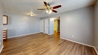 Located at 1301 N State Highway 121 in Bonham, TX, this 2-bedroom, 2-bathroom unit offers a practical and comfortable layout across a single floor. Wood-look flooring runs throughout the entire space, providing a cohesive and easy-to-maintain surface in every room. Textured ceilings and ceiling fans with light fixtures are present in the main living areas and bedrooms, contributing to a classic residential aesthetic.

The combined kitchen and living room serves as the heart of the unit. The kitchen is equipped with white upper cabinetry with wood trim accents, ample counter space, a double-basin sink, and black appliances including a range and dishwasher, alongside a white refrigerator. The living area flows naturally from the kitchen, offering a spacious open feel.

Both bedrooms feature natural light through window blinds, ceiling fans, and ample wall space. The primary bedroom includes access to a dedicated walk-in closet with wraparound hanging rods, offering generous storage capacity. The two bathrooms are each fitted with a tub/shower combination surrounded by patterned tile, a vanity with wood-trim cabinetry, and a large mirror. A hallway connects the bedrooms and bathrooms, providing a logical and efficient traffic flow throughout the unit.