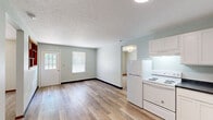 Located at 4285 Kent Rd in Stow, Ohio, this two-bedroom, one-bathroom unit offers a practical and well-organized single-floor layout. The combined living, dining, and kitchen area forms the heart of the home, featuring light hardwood-style flooring, soft sage-green walls, and a textured ceiling. Natural light filters in through multiple windows, creating a bright and welcoming atmosphere. A charming pass-through window with warm wood shelving connects the living area to the kitchen, adding a distinctive architectural detail.

The kitchen is outfitted with white shaker-style cabinetry, dark countertops, a stainless steel sink, and white appliances including a refrigerator and electric range. The two bedrooms offer a comfortable retreat — the primary bedroom is generously sized and carpeted, while the second bedroom features hardwood-style flooring and a bright window with outdoor views. Three closets, including a spacious walk-in with wire shelving, provide ample storage throughout.

The bathroom is designed with accessibility in mind, featuring a walk-in shower with grab bars, tile flooring, and warm wood cabinetry. This thoughtfully laid-out unit combines functional design with clean finishes throughout.