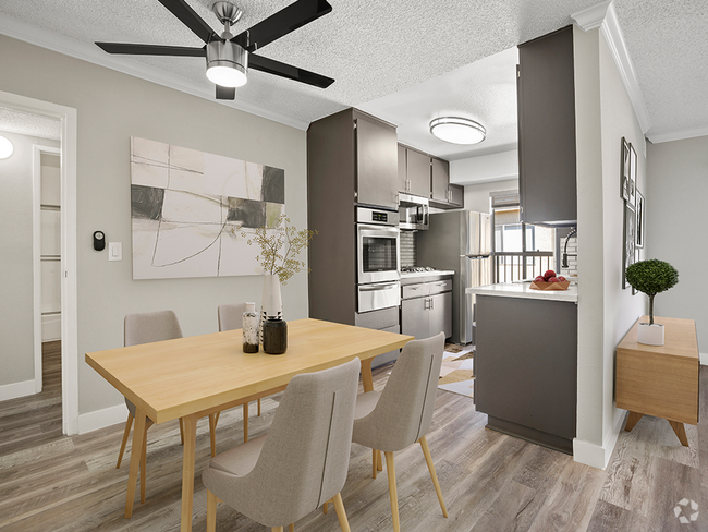 Hardwood floored dining room with view of modern-styled kitchen. - Tilden II Apartments