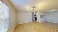 Located at 5131 Bundy Rd in New Orleans, LA, this single-floor, 2-bedroom, 3-bathroom home offers a well-organized layout designed for comfortable everyday living. Light wood-look flooring runs consistently throughout, lending a cohesive and clean aesthetic to every room. The living area is anchored by a striking sputnik-style chandelier and flows seamlessly into the dining space, which features its own matching statement light fixture and a window that fills the room with natural light. The kitchen is outfitted with white shaker-style cabinetry, granite-look countertops, stainless steel appliances including a refrigerator and range, and a pass-through to the adjacent dining area. Both bedrooms are comfortably sized, with the primary bedroom offering generous square footage, and each room is equipped with a ceiling fan and window with blinds for natural ventilation and light control. The three bathrooms are finished consistently with white vanities, mirrors, and matching flooring. A dedicated closet and hallway provide practical storage and connectivity throughout the home. Textured ceilings and neutral gray walls create a calm, move-in-ready atmosphere throughout this efficiently designed New Orleans residence.