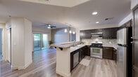 Located at 1195 Selmi Dr in Reno, Nevada, this well-appointed 2-bedroom, 3-bathroom single-floor residence offers a thoughtfully designed layout with modern finishes throughout. The open-concept kitchen and living area serves as the heart of the home, featuring dark espresso cabinetry, a mosaic tile backsplash, stainless steel appliances including a gas range and built-in microwave, and a peninsula with a light stone countertop that provides both prep space and casual seating. Recessed lighting and pendant fixtures illuminate the kitchen, while a ceiling fan keeps the adjacent living area comfortable. Sliding glass doors flood the living space with natural light and lead directly to an outdoor area. The bedrooms are carpeted for comfort, with one featuring a dedicated walk-in closet outfitted with wire shelving for ample storage. The bathrooms are finished with dark wood vanities, stone-topped counters, and large mirrors. A dedicated laundry room includes a full-size side-by-side washer and dryer with overhead wire shelving. Light wood-tone flooring runs throughout the main living areas, tying together the home's clean, contemporary aesthetic.