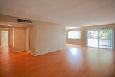 Located at 5140 White Oak Ave in the Encino neighborhood of Los Angeles, this single-floor residence offers a well-organized layout with a seamless flow between living spaces. The main living area is a generously proportioned room featuring warm hardwood flooring that extends throughout, neutral-toned walls, and a textured ceiling. Large windows fitted with vertical blinds and a sliding glass door allow abundant natural light to fill the space, with views of lush greenery outside. A ceiling fan provides additional comfort in the living area.

The kitchen is thoughtfully designed with rich wood cabinetry offering ample storage, granite countertops, and black appliances including a gas range and refrigerator. A double sink and galley-style layout make the kitchen both functional and efficient.

The bedroom features plush carpeting, neutral walls, and a large window with vertical blinds that invite natural light and outdoor views. The bathroom is appointed with dual granite-topped vanity sinks, a large wall mirror, a soaking tub, and a separate shower stall, combining practicality with a refined finish. Throughout, the space maintains a clean, understated aesthetic suited for comfortable everyday living.