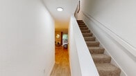 Located at 2 Hiltin Pl in Greensboro, NC, this two-story, three-bedroom home offers a well-organized layout spread across two comparable floors. Light wood-style flooring flows throughout the main level, creating a warm and cohesive atmosphere from entry to living space.

The main floor opens to a hallway framed by carpet-lined stairs leading to the upper level. The combined living and dining area is bright and open, with the living room featuring a large sliding glass door that invites natural light and provides outdoor views. The adjacent dining area showcases light wood floors and is accented by a statement art piece overhead. The kitchen is thoughtfully designed with white cabinetry, granite-style countertops, a classic subway tile backsplash, stainless steel appliances, and a window that brings in additional natural light.

Upstairs, the three bedrooms are carpeted for comfort, each offering closet space and natural light through well-placed windows. The spacious primary bedroom includes a ceiling fan and a generous closet. The full bathroom features white cabinetry, a dark granite-topped vanity, a round mirror, and a tub-shower combination, providing a clean and functional space shared across the home.