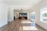Located at 1700–1726 Madison Ave in Kansas City, MO, this contemporary single-floor residence showcases a thoughtfully designed open-concept layout that seamlessly connects the living area and kitchen. Rich hardwood flooring runs throughout the main living space, complementing the clean white walls and recessed lighting that give the interior a bright, airy feel.

The kitchen is a standout feature, outfitted with bold navy cabinetry, a substantial island topped with white quartz countertops, stainless steel appliances, and a subway tile backsplash. A circular pendant light anchors the space, adding a modern touch. The open layout ensures the kitchen flows naturally into the expansive living area.

Large windows and glass French doors flood the living space with natural light while providing views of and access to an outdoor balcony. The bedroom offers plush carpeting, a ceiling fan, and a generous walk-in closet with dual hanging rods. Two bathrooms serve the unit — one featuring a soaking tub, a separate glass-enclosed shower, and a tall wood storage cabinet, while the other offers a clean, minimal design with wood-toned cabinetry and light tile flooring throughout. The overall ambiance is polished, contemporary, and welcoming.