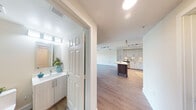 Located at 6460 Main St in Miami Lakes, FL, this well-appointed 2-bedroom, 2-bathroom residence offers a thoughtfully designed single-floor layout with modern finishes throughout. Light wood-look flooring flows through the open-concept living and dining area, which is bathed in natural light and opens directly onto a private balcony through sliding glass doors — offering pleasant outdoor views framed by palm trees. A ceiling fan adds comfort to the airy living space.

The kitchen is a standout feature, showcasing contemporary flat-front cabinetry, stainless steel appliances including a dishwasher, range, and microwave, white quartz countertops, a mosaic tile backsplash, and track lighting overhead. A central island provides additional prep and casual dining space.

The spacious primary bedroom features plush carpeting, a ceiling fan, a large window with natural views, and access to a well-organized walk-in closet with built-in shelving and hanging rails. The primary bathroom is elegantly appointed with a soaking tub, glass-enclosed shower, a long vanity with white cabinetry, and wood-look flooring. The second bedroom also benefits from natural light and hardwood-style flooring. A dedicated closet and a second full bathroom complete the layout.