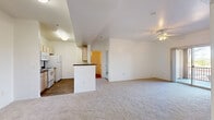 Located in Peoria, Arizona, this single-floor 3-bedroom, 2-bathroom unit offers a practical and well-organized layout. The open-concept living and dining area features plush carpeting and a ceiling fan, seamlessly connecting to the kitchen via a peninsula-style breakfast bar. The galley kitchen is equipped with white appliances including an electric range, microwave, and refrigerator, complemented by light wood cabinetry and dark countertops, all set over wood-look flooring. Three carpeted bedrooms provide comfortable retreats, with the primary bedroom featuring a walk-in closet with built-in shelving and a window that brings in natural light. The two bathrooms are finished with wood-look flooring, white vanity cabinetry, dark countertops, and tub-shower combinations. A dedicated laundry area includes an in-unit washer and additional shelving. Storage is well-addressed with two closets, including a generously sized walk-in closet with multi-level shelving and a small window for natural light. Throughout the unit, clean white walls and neutral tones create a bright, move-in-ready atmosphere suited for comfortable everyday living.