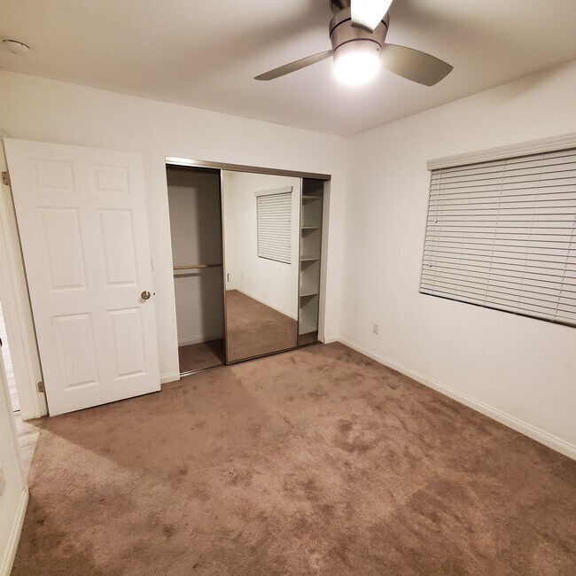 Dormitorio con armario con espejos. Estantes y dos barras para colgar ropa. - 5731 Fulton Ave