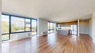 This well-appointed 2-bedroom, 3-bathroom residence in Hackensack, NJ offers a thoughtfully designed single-floor layout with modern finishes throughout. The open-concept kitchen and living area serves as the heart of the home, showcasing rich wood-grain cabinetry extending to the ceiling, a suite of stainless steel appliances including a range, over-the-range microwave, dishwasher, and refrigerator, complemented by a quartz-topped island and a neutral tile backsplash. Hardwood flooring flows seamlessly throughout the living spaces. The living area is bathed in natural light through dramatic floor-to-ceiling corner windows offering expansive outdoor views. Both bedrooms are generously sized, each featuring sliding windows with outdoor views and individual climate control units. The spacious primary bedroom includes a dedicated closet. Three contemporary bathrooms feature marble-style porcelain tile flooring, quartz countertops, and modern wood-toned vanities. The primary bathroom offers a dual-sink vanity and walk-in glass-enclosed shower with marble-style tile surround. A connecting hallway with recessed lighting ties all rooms together, contributing to a clean, functional, and modern overall ambiance.