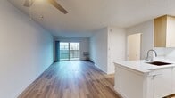 This 580 square foot apartment in Newport Beach offers a thoughtful blend of functionality and style. The single-level floor plan comprises one bedroom, one bathroom, and an open-concept living area, making efficient use of the available space.

The living room is bright and airy, with smooth white walls and large sliding glass doors that invite natural light and potentially offer outdoor views. The flooring throughout is a warm, honey-toned hardwood, adding warmth and continuity to the space.

The bedroom, measuring 210 square feet, features mirrored closet doors that enhance the sense of space and light. A ceiling fan provides comfort and air circulation.

The bathroom is clean and modern, with a white tub-shower combination, chrome fixtures, and a simple, functional design.

The kitchen is a highlight, boasting sleek white cabinetry, stainless steel appliances, and a peninsula with a deep sink, perfect for meal prep or casual dining. Light wood accents and under-cabinet lighting add depth and functionality to the space.

Throughout the apartment, recessed lighting and strategically placed windows contribute to a bright, open feel. The neutral color palette and contemporary finishes create a canvas ready for personalization, making this compact coastal residence an ideal urban retreat.
