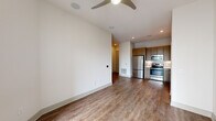 This well-appointed one-bedroom, one-bathroom residence in Houston's vibrant Midtown neighborhood offers a thoughtfully designed open-concept layout with modern finishes throughout. Wood-style plank flooring flows seamlessly across the living, dining, and kitchen areas, complemented by crisp white walls and clean-lined baseboards that create a bright, cohesive aesthetic.

The living room is a comfortable, light-filled space anchored by a ceiling fan and sliding glass doors that open to a private balcony with a metal railing — an ideal spot to take in the surrounding neighborhood. The kitchen is a standout feature, boasting flat-front wood-toned cabinetry extending to the ceiling, a neutral tile backsplash with under-cabinet lighting, light quartz countertops, and a full suite of stainless steel appliances including a refrigerator, range, microwave, and dishwasher.

The bedroom is a quiet, well-proportioned retreat with a window allowing natural light and direct access to a dedicated closet. The bathroom is finished with warm wood-toned vanity cabinetry, a framed mirror, white quartz countertop, tile flooring, and a tub/shower combination featuring marble-style tile surround. Every detail reflects a clean, contemporary design suited for comfortable everyday living.
