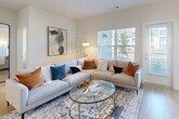 Located at 1551 Riverside Pkwy in Douglasville, GA, this thoughtfully designed single-floor home offers two bedrooms, two bathrooms, and a practical, open-concept layout. Light wood-style flooring flows throughout the main living areas, complemented by crisp white walls and recessed lighting that create a bright, clean aesthetic.

The entry hallway welcomes you with a built-in wall-mounted coat rack and leads seamlessly into the main living spaces. The living room is generously proportioned, featuring large windows with plantation shutters that bathe the space in natural light. The kitchen is a standout, boasting white shaker cabinetry, a subway tile backsplash, stainless steel appliances, and a center island with quartz countertops and pendant lighting — ideal for both cooking and casual dining.

The primary bedroom features plush carpeting, a ceiling fan, and multiple windows offering ample natural light. The second bedroom offers versatility, with soft carpet and enough space to function as a home office or guest room. Both bathrooms are finished with white vanities, quartz countertops, and tiled tub-shower combinations. A dedicated laundry room with side-by-side washer and dryer adds everyday convenience. Three closets provide excellent storage throughout the home.