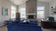 Located at 55 Eastpointe Ridge Dr in Columbus, Ohio, this well-appointed single-floor space makes a strong architectural impression from the moment you enter. The centerpiece of the interior is a generously proportioned living area showcasing soaring vaulted ceilings that amplify the sense of openness and volume. A dramatic floor-to-ceiling gray brick fireplace anchors the room, complete with a crisp white mantel that provides a clean contrast against the textured masonry. Multiple large windows flank the fireplace on both sides, flooding the space with abundant natural light and offering views of the surrounding neighborhood. The neutral gray wall tones complement the architectural details, creating a cohesive and contemporary aesthetic throughout. The living area is well-suited for both relaxed gatherings and more formal settings, offering ample room for comfortable seating arrangements. The single-floor layout ensures seamless flow and accessibility throughout the space. Overall, the interior strikes a balance between modern design sensibility and welcoming warmth, making it a functional and visually appealing environment well-suited to a variety of uses.