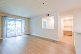 This well-appointed single-floor residence offers a thoughtfully designed open-concept layout that seamlessly connects the living, dining, and kitchen areas. Light-toned hardwood-style flooring runs throughout the main living spaces, contributing to a bright and cohesive aesthetic. The spacious living area is filled with natural light through large sliding glass doors that open onto a private balcony, offering pleasant views of surrounding greenery.

The kitchen is efficiently laid out with light wood cabinetry, ample counter space with a granite-style surface, a gas range, built-in microwave, dishwasher, and a full-size refrigerator. A peninsula with a sink provides additional workspace and a natural division between the kitchen and living area. Track lighting overhead ensures the kitchen is well illuminated.

Two generously sized bedrooms feature plush carpeting and large windows that frame lush tree-lined views, bringing abundant natural light into each room. One bedroom includes a ceiling fan and a secondary door, adding to its functionality.

The unit includes two full bathrooms, each finished with hardwood-style flooring, a tub-shower combination, vanity with storage, and clean white fixtures. The neutral color palette throughout the entire space creates a calm, versatile environment suitable for a variety of interior styles.