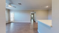 Located in Rancho Cucamonga, CA, this well-appointed 3-bedroom, 2-bathroom residence offers a thoughtfully designed single-level layout with generous living space. The open-concept kitchen and living area serves as the heart of the home, featuring white shaker cabinetry, a sleek stainless steel appliance suite including a French door refrigerator and range, a stylish tile backsplash, a stainless steel wall-mounted range hood, and a large center island with bright white quartz countertops. Wood-style flooring flows throughout the main living areas, while the spacious living room is highlighted by crown molding, a ceiling fan, a cozy fireplace, and windows that invite ample natural light. A private balcony extends the living space outdoors. The generously sized primary bedroom includes plush carpeting, a dedicated closet, and direct access to an en-suite bathroom. Two additional bedrooms, each carpeted and naturally lit with window blinds, share a well-appointed full bathroom complete with a tub-shower combination and wood-look tile flooring. A hallway connects the bedrooms and provides access to additional closet storage. Neutral tones and clean finishes throughout create a bright, move-in ready atmosphere.