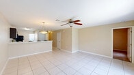 Located at 161 Heather Oaks Cir in Lady Lake, Florida, this two-story home offers a functional and well-organized layout across two floors. The main level provides the larger share of the living space and features an open-plan kitchen and dining area finished with light ceramic tile flooring. The kitchen is equipped with dark espresso cabinetry, black appliances including a range, microwave, and refrigerator, and a double-basin sink with a pass-through counter that connects seamlessly to the dining area. Pendant and ceiling fan lighting brighten the combined space, and a sliding door brings in natural light. The upper level houses all three bedrooms, including a generously sized primary bedroom, along with a hallway and two staircases providing access between floors. The bedrooms feature neutral-toned carpet, ceiling fans, and closets, with windows offering views of the surrounding greenery. Three closets throughout the home provide ample storage. Both bathrooms are fitted with tub-shower combinations, white tile surrounds, vanity mirrors, and light fixtures. The home's warm, neutral color palette and practical layout make it a comfortable residence in the Lady Lake community.