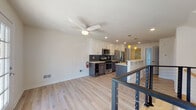 This well-designed two-floor residence offers a thoughtful layout with contemporary finishes throughout. The upper level centers around an open-concept kitchen and living area, where light wood-look flooring, recessed lighting, and a ceiling fan create a bright, airy atmosphere. The kitchen is well-appointed with white upper cabinetry, dark lower cabinets, light stone countertops, a dark tile backsplash, and a full suite of stainless steel appliances including a gas range, microwave, and refrigerator. A large island with an integrated sink and pendant lighting adds both function and style, while French doors at the far end of the living area invite natural light. A modern staircase with a sleek metal cable railing connects the two floors.

The lower level offers generously sized rooms, including a bright bedroom with a large window overlooking greenery, and an open flex room featuring built-in wood niche shelving and a skylight opening to the upper floor above. The lower level also includes a clean, modern full bathroom with a large glass-enclosed walk-in shower finished in white subway tile and a rainfall showerhead. A dedicated laundry area with a full-size washer and dryer adds everyday convenience. Throughout both levels, the consistent use of light flooring and neutral tones creates a cohesive, contemporary living environment.