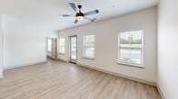 Located at 91 Wiltons Way in Bluffton, SC, this single-story 2-bedroom, 1-bathroom home offers a thoughtfully designed layout filled with modern finishes and an abundance of natural light. The open-concept kitchen and living area serves as the heart of the home, showcasing white shaker-style cabinetry with sleek black hardware, white quartz countertops, a bold navy blue kitchen island with pendant lighting, and stainless steel appliances including a side-by-side refrigerator, range, and microwave. A white subway tile backsplash adds a clean, classic touch. The spacious living room features light wood-look LVP flooring, a ceiling fan, and multiple windows with views of the outdoors, creating a bright and airy atmosphere. Both bedrooms are well-sized, each equipped with ceiling fans and natural light from multiple windows. The primary bedroom offers a comfortable footprint ideal for a full bedroom suite. The full bathroom is finished with a tiled tub-shower combination, brushed nickel fixtures, and wood-look flooring. A dedicated laundry room houses a full-size Whirlpool washer and dryer. Additional storage is provided by an in-unit closet, rounding out this efficiently designed Bluffton residence.
