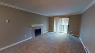 Located at 23401 16th Ave S in Des Moines, Washington, this single-floor residence offers a well-designed layout with a warm and inviting atmosphere throughout. The living room serves as the heart of the home, featuring a tile-surround fireplace with a classic white mantle, soft wall-to-wall carpeting, and crown molding that adds a refined touch. A sliding glass door dressed with vertical blinds fills the space with natural light and provides access to the outdoors.

The kitchen is thoughtfully appointed with warm wood cabinetry, light countertops, and a full suite of stainless steel appliances including a refrigerator, dishwasher, and range with overhead ventilation. Track lighting illuminates the space, which also includes hardwood flooring and an in-unit washer for added convenience.

The bedrooms are carpeted and finished with crown molding, each offering natural light through blinds-fitted windows and baseboard heating. The bathrooms are clean and functional, with one featuring a full tub-shower combination with white tile surround, and another offering a wood-cabinet vanity, tile flooring, and modern fixtures. Neutral wall tones and consistent finishes throughout create a cohesive and comfortable living environment.