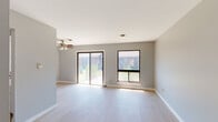 This single-floor, one-bedroom, one-bathroom unit in Burbank, Illinois, offers a clean, modern aesthetic throughout. Light wood-tone flooring runs consistently across the living areas and bedroom, contributing to a cohesive and airy feel. Neutral gray walls provide a versatile backdrop that complements the overall design.

The entry hallway features a flush-mount ceiling light and leads into the main living area, which is generously proportioned and bathed in natural light from a sliding glass door and an adjacent window. The sliding door provides outdoor views and direct access to the exterior, while a ceiling fan enhances comfort year-round.

The kitchen is set just off the living area, accessed via a pass-through countertop with a built-in sink that creates an open, connected feel. The kitchen itself features light-toned cabinetry, white countertops, and a stainless steel gas range with an overhead ventilation hood. A refrigerator is also included.

The bedroom is a comfortable, well-lit room with a window overlooking the outdoors and light flooring consistent with the rest of the unit. A closet with bi-fold doors offers convenient storage nearby.

The bathroom includes a full tub/shower combo, a white vanity with sink, a medicine cabinet with mirror, and wood-tone flooring, completing this functional and tidy unit.