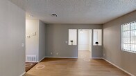 Located at 44710 Division Street in Lancaster, CA, this single-floor, 2-bedroom, 2-bathroom unit offers a practical and well-organized layout. The living room features light wood-style flooring, neutral gray walls, and a textured ceiling, with an open pass-through connecting it to the dining area and kitchen. Vertical blinds on the windows allow for natural light control throughout. The kitchen is outfitted with white cabinetry, light countertops, a gas range, dishwasher, and a stainless steel sink — all finished with the same wood-style flooring for a cohesive look. A dedicated dining area sits adjacent to the kitchen, providing a functional space for everyday meals. Both bedrooms are carpeted and feature gray walls, textured ceilings, and closets for ample storage. The primary bedroom is generously sized and includes a sliding closet. The two bathrooms are cleanly finished in white, each featuring light wood-style flooring, a vanity, and toilet. One bathroom includes a full shower/tub combination, while the second offers a windowed wall for added ventilation. A hallway connects the bedroom wing to the main living areas, completing this efficiently designed residential unit.
