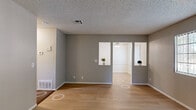Located at 44710 Division Street in Lancaster, CA, this single-floor, 2-bedroom, 2-bathroom unit offers a practical and well-organized layout. The living room features light wood-style flooring, neutral gray walls, and a textured ceiling, with an open pass-through connecting it to the dining area and kitchen. Vertical blinds on the windows allow for natural light control throughout. The kitchen is outfitted with white cabinetry, light countertops, a gas range, dishwasher, and a stainless steel sink — all finished with the same wood-style flooring for a cohesive look. A dedicated dining area sits adjacent to the kitchen, providing a functional space for everyday meals. Both bedrooms are carpeted and feature gray walls, textured ceilings, and closets for ample storage. The primary bedroom is generously sized and includes a sliding closet. The two bathrooms are cleanly finished in white, each featuring light wood-style flooring, a vanity, and toilet. One bathroom includes a full shower/tub combination, while the second offers a windowed wall for added ventilation. A hallway connects the bedroom wing to the main living areas, completing this efficiently designed residential unit.