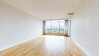 Located at 7307 Campeau Dr in Ottawa's Kanata neighbourhood, this 2-bedroom, 2-bathroom unit offers a well-designed single-floor layout with a clean, contemporary aesthetic throughout. Light hardwood flooring flows seamlessly across the living areas and bedrooms, contributing to a bright and cohesive feel.

The spacious living room is a standout feature, anchored by expansive floor-to-ceiling windows and a sliding glass door that frame sweeping panoramic views of the Ottawa cityscape, flooding the space with natural light. The kitchen is efficiently designed with white shaker-style cabinetry, grey countertops, a classic white subway tile backsplash, and stainless steel appliances including a range, microwave, and dishwasher. A breakfast bar provides additional counter space and connectivity to the living area.

Both bedrooms are comfortably sized with hardwood floors and neutral tones, offering a calm and restful atmosphere. The primary bedroom benefits from generous proportions. The two bathrooms are finished with light tile flooring and white subway tile surrounds — one featuring a soaker tub and shower combination, and the other a sleek glass-enclosed walk-in shower, both appointed with brushed nickel fixtures.