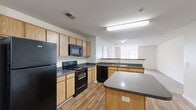 Located at 830 Aloonby Rd in Fayetteville, NC, this single-story, 3-bedroom, 3-bathroom home delivers a practical and comfortable layout designed for everyday living. The open-concept kitchen and living area form the heart of the home, featuring light oak cabinetry, dark granite-style countertops, a center island, and a full suite of black appliances including a refrigerator, electric range, microwave, and dishwasher. Wood-look flooring runs throughout the kitchen, which flows seamlessly into a bright, carpeted living room with natural light from large windows. Each of the three bedrooms is carpeted and outfitted with a ceiling fan, closet access, and neutral wall tones that offer a clean, versatile canvas. The spacious primary bedroom includes a walk-in closet with wire shelving for organized storage. The three bathrooms feature wood-look flooring and shower-tub combinations with clean white surrounds. A dedicated laundry room provides washer and dryer hookups, wire shelving, and an electrical panel for added convenience. A pantry and hallway round out the well-organized floor plan, making this home a practical choice in the Fayetteville area.